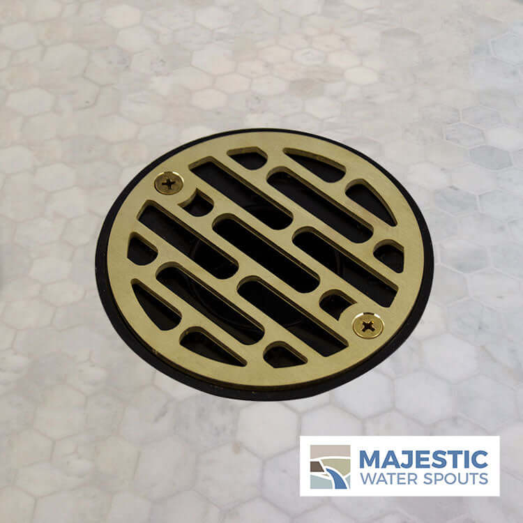 https://majesticwaterspouts.com/cdn/shop/products/Designer_Brushed_Brass_Shower_Drain_Cover_Strainer_On_Marble_Galleria_Small_logo_1024x1024.jpg?v=1643293743