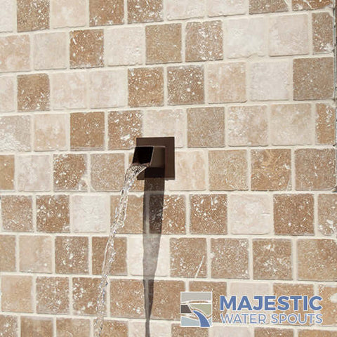 Rust color Square water spout installed in tile wall outdoors