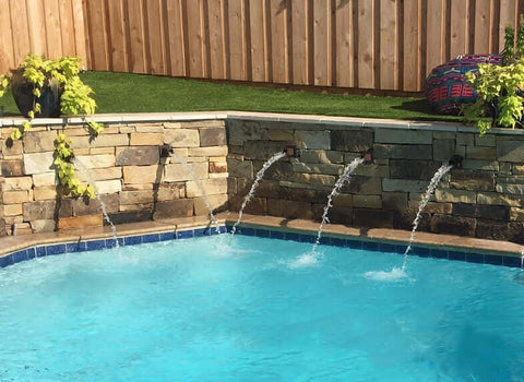 Rust color Square water spouts installed in pool fountain water feature outdoors
